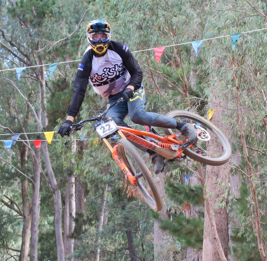 Sean Mc jumping dh bike ina nz made urban grey Rockstar Anzac camouflage dh top.